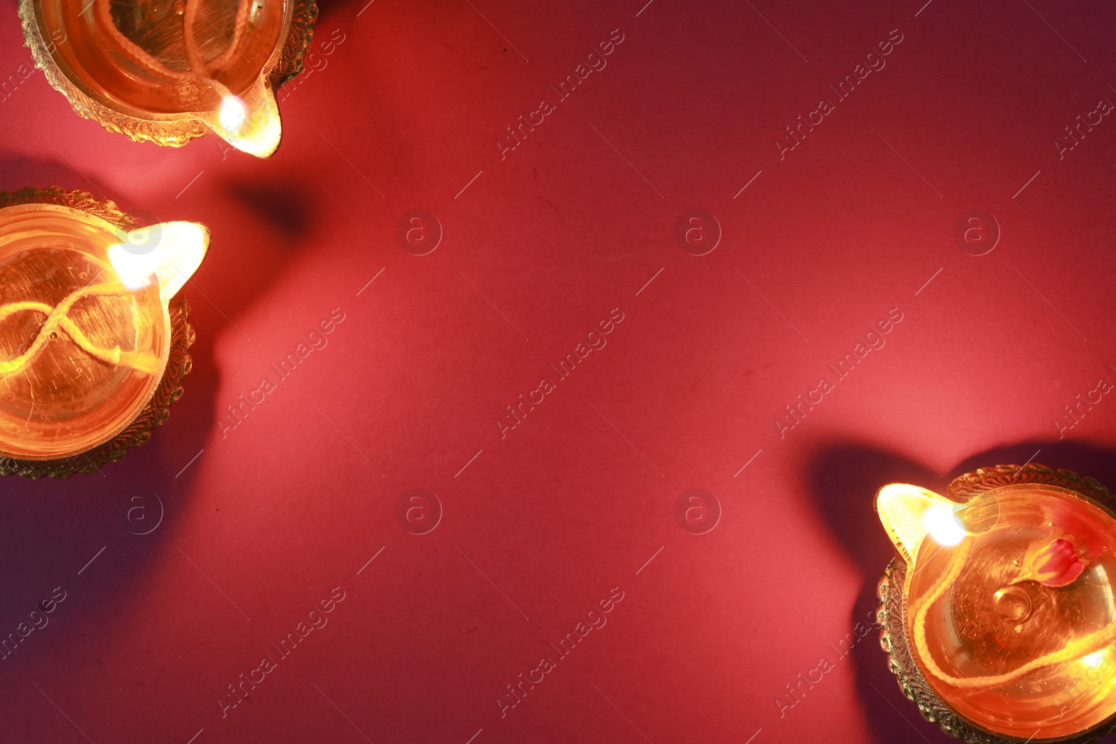 Photo of Diwali celebration. Diya lamps on color background, flat lay. Space for text