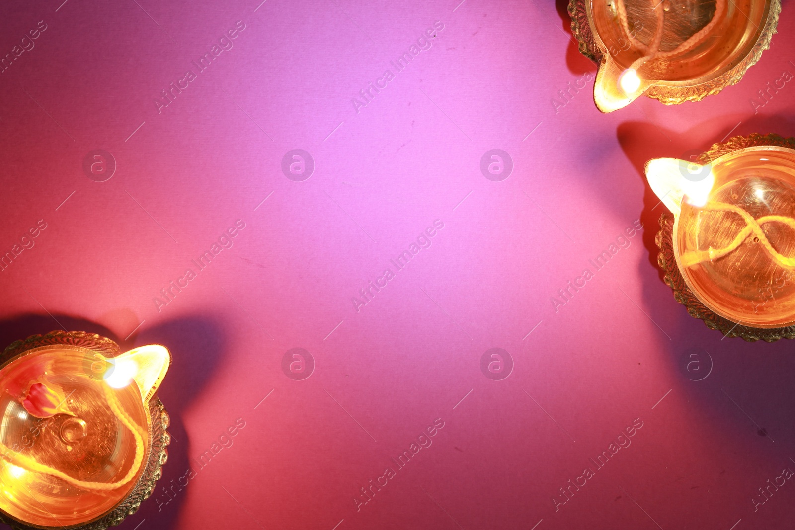 Photo of Diwali celebration. Diya lamps on color background, flat lay. Space for text