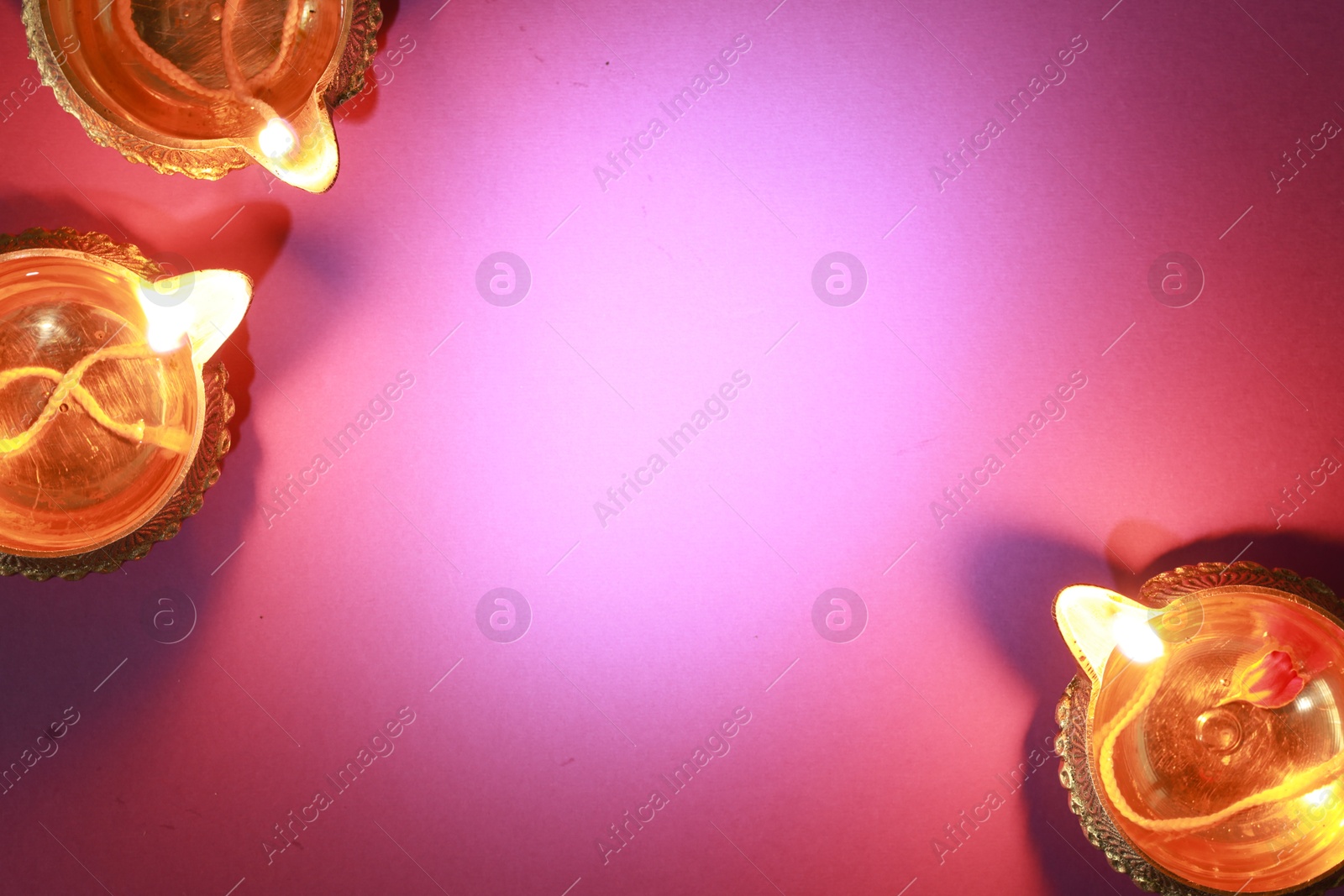 Photo of Diwali celebration. Diya lamps on color background, flat lay. Space for text