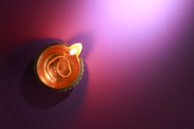 Diwali celebration. Diya lamp on color background, top view. Space for text