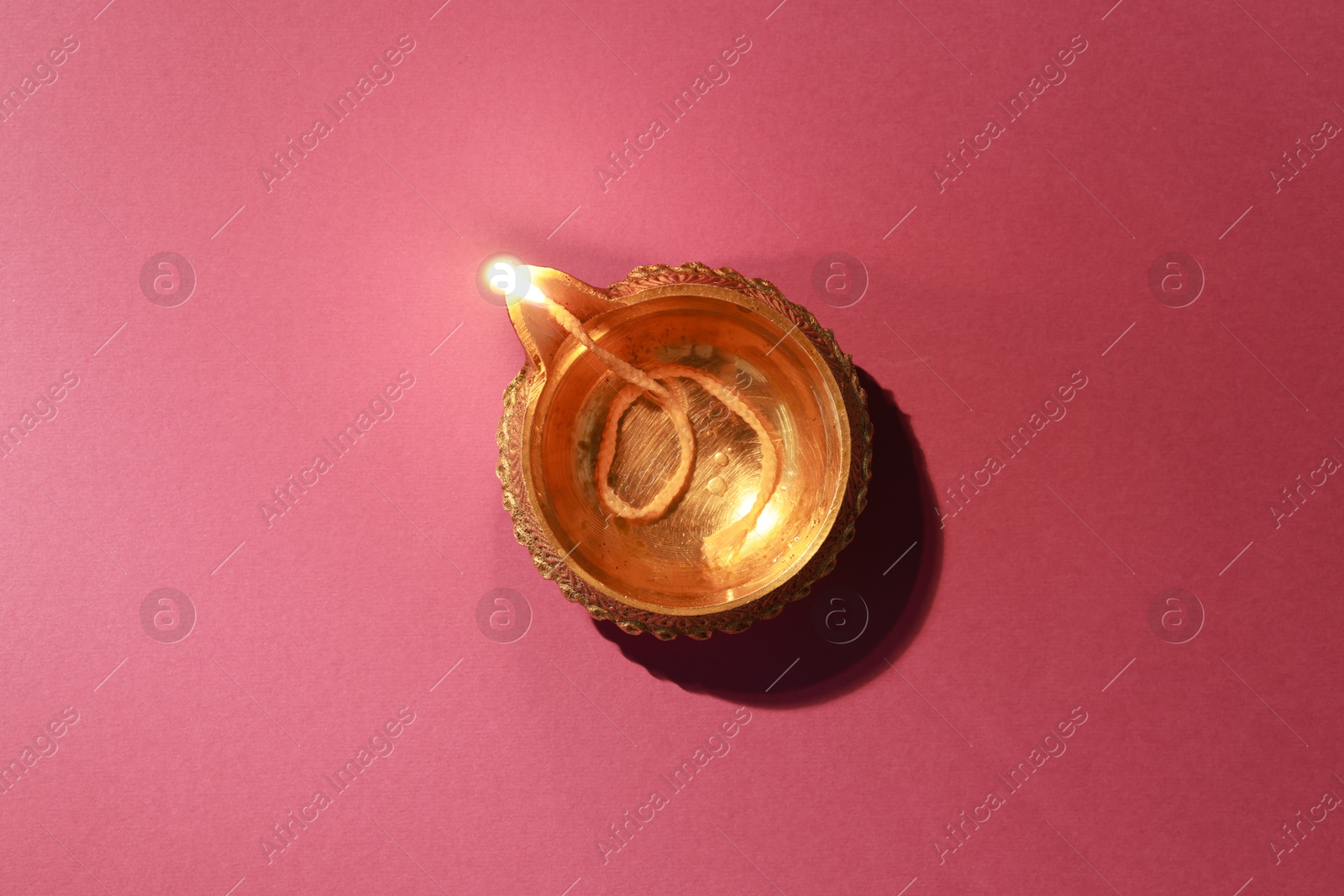 Photo of Diwali celebration. Diya lamp on color background, top view