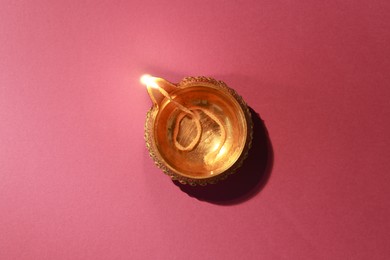 Diwali celebration. Diya lamp on color background, top view