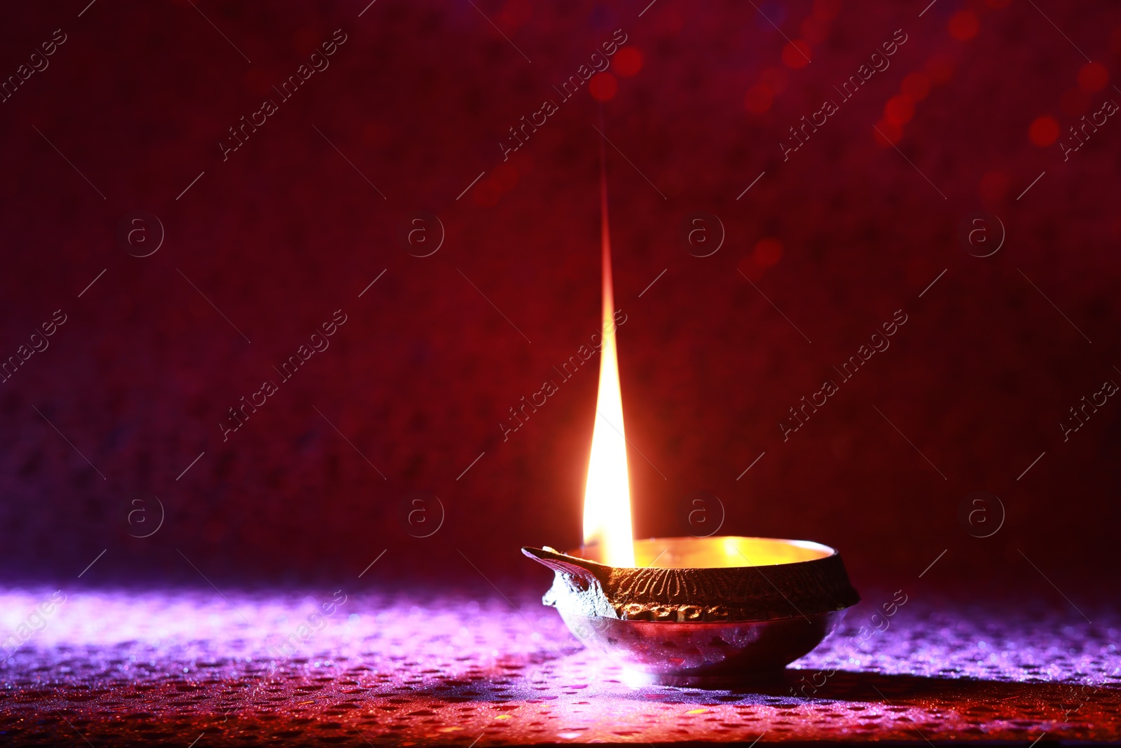 Photo of Diwali celebration. Diya lamp on red background. Space for text