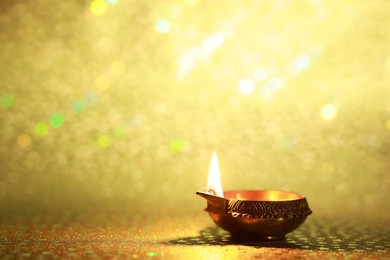 Photo of Diwali celebration. Diya lamp on golden background. Space for text