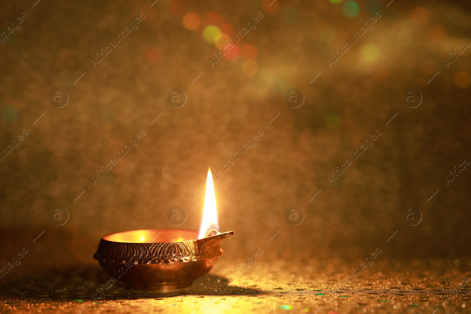 Photo of Diwali celebration. Diya lamp on golden background. Space for text