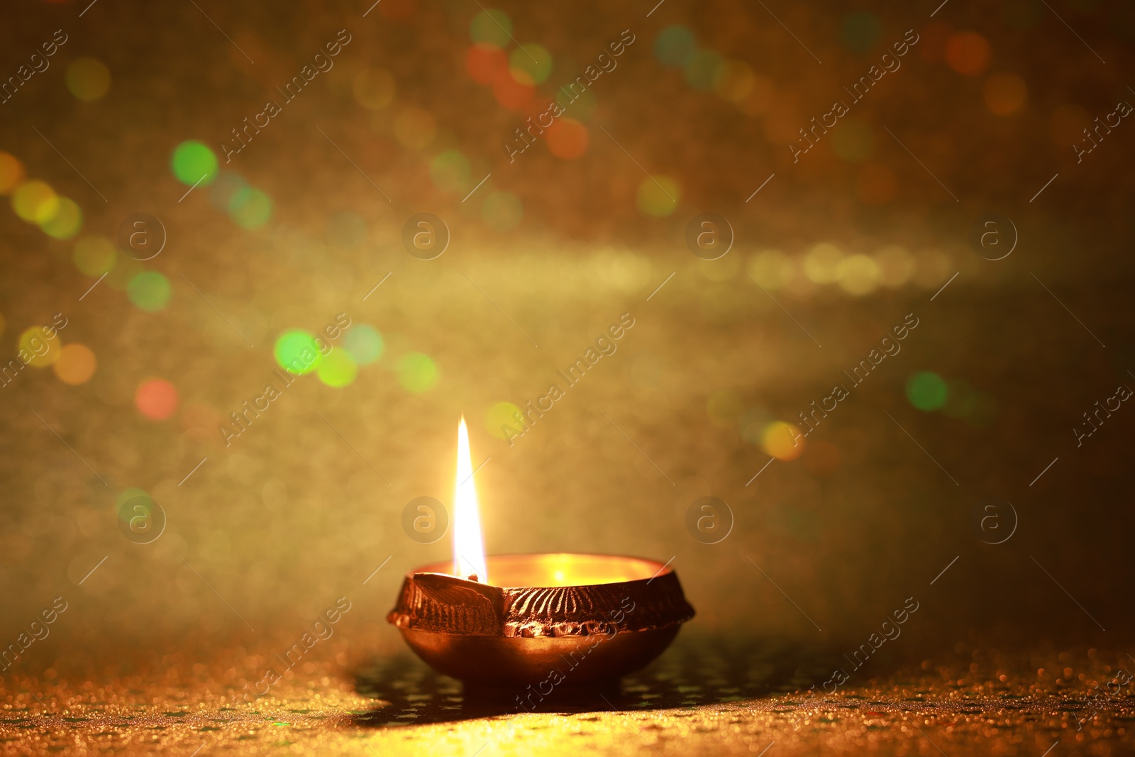 Photo of Diwali celebration. Diya lamp on golden background. Space for text