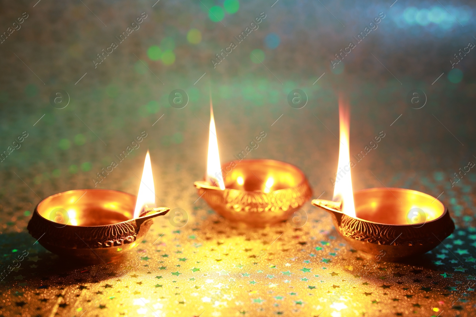 Photo of Diwali celebration. Diya lamps on color background