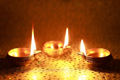 Photo of Diwali celebration. Diya lamps on color background