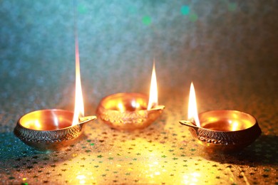 Photo of Diwali celebration. Diya lamps on color background