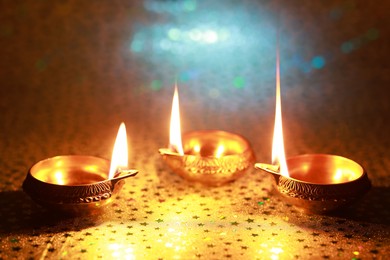 Photo of Diwali celebration. Diya lamps on color background