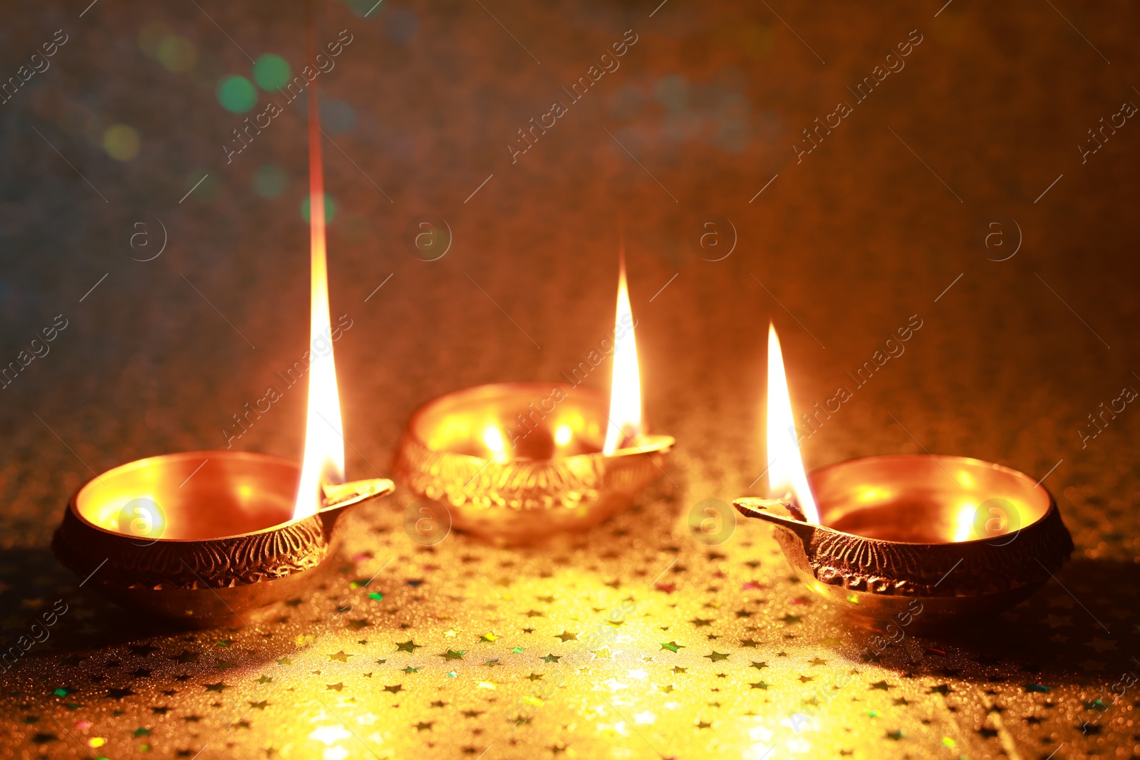 Photo of Diwali celebration. Diya lamps on color background