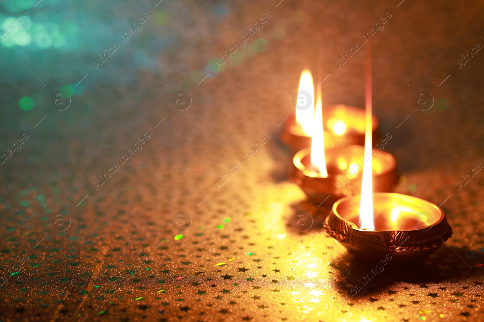 Photo of Diwali celebration. Diya lamps on color background. Space for text