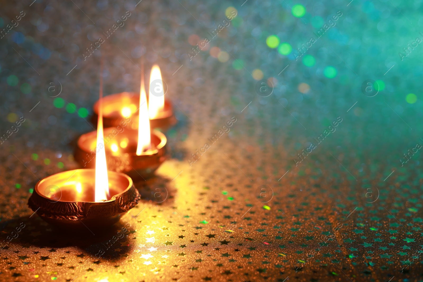 Photo of Diwali celebration. Diya lamps on color background. Space for text