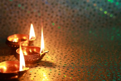 Photo of Diwali celebration. Diya lamps on color background. Space for text