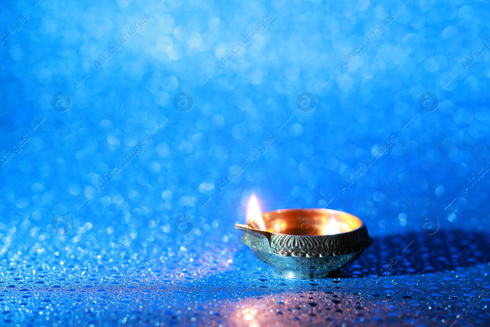 Photo of Diwali celebration. Diya lamp on blue background. Space for text