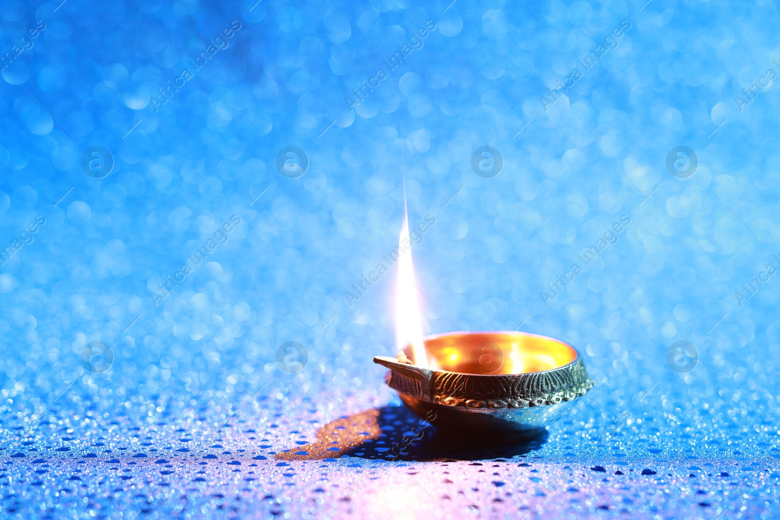 Photo of Diwali celebration. Diya lamp on blue background. Space for text