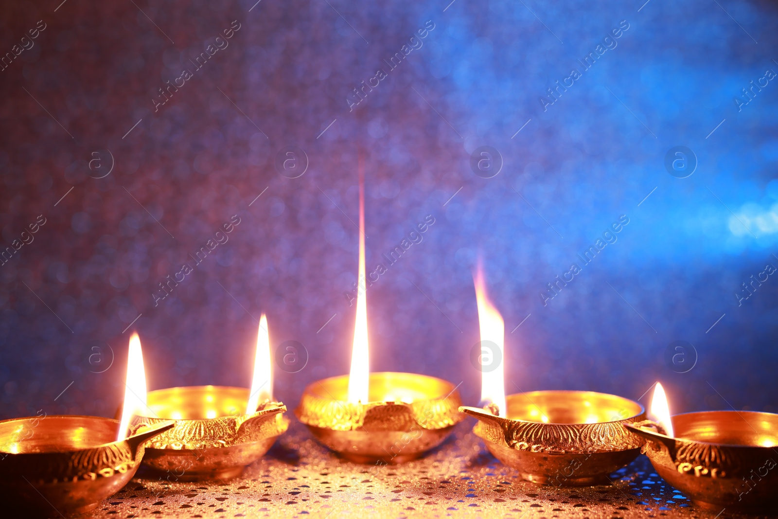 Photo of Diwali celebration. Diya lamps on color background. Space for text