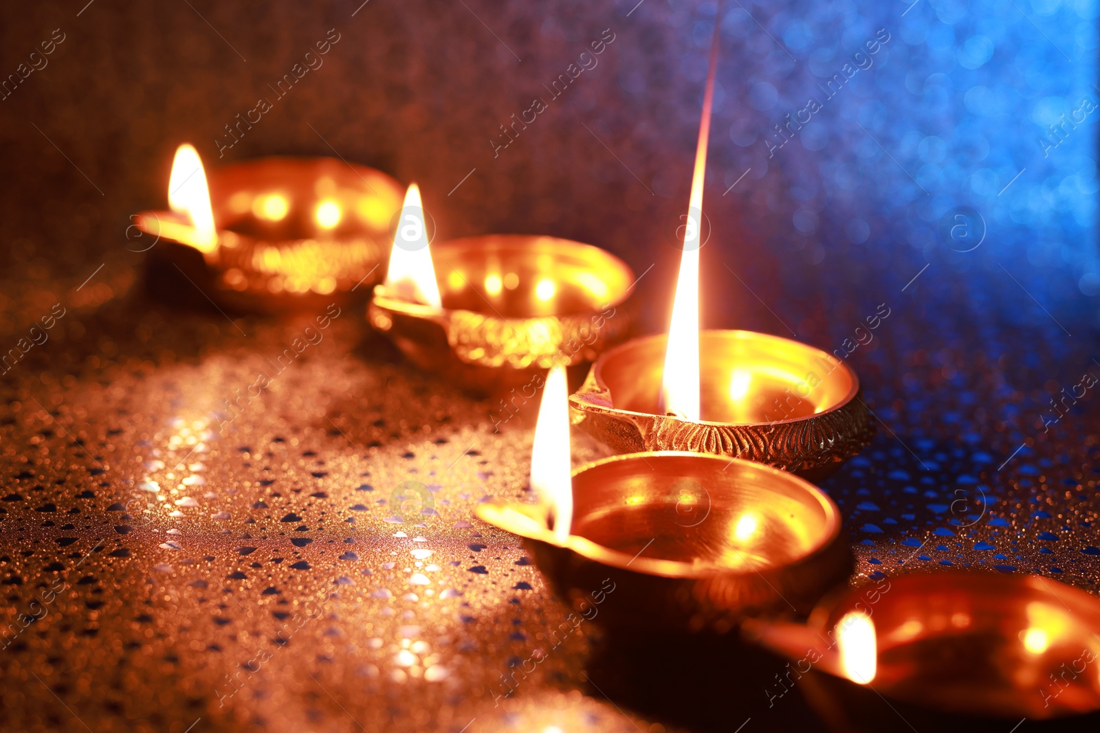 Photo of Diwali celebration. Diya lamps on color background, closeup