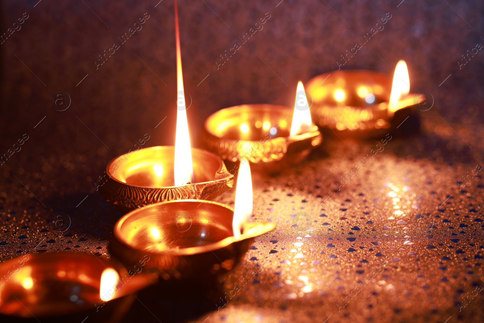 Photo of Diwali celebration. Diya lamps on color background, closeup