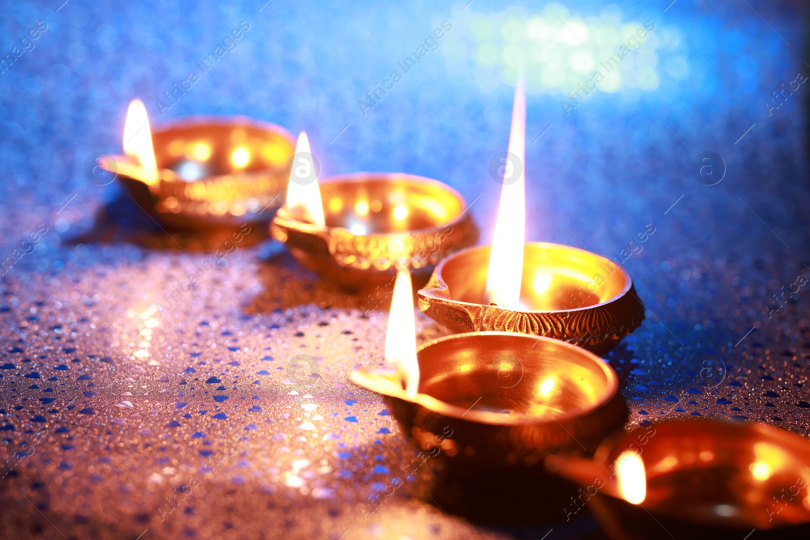 Photo of Diwali celebration. Diya lamps on color background, closeup