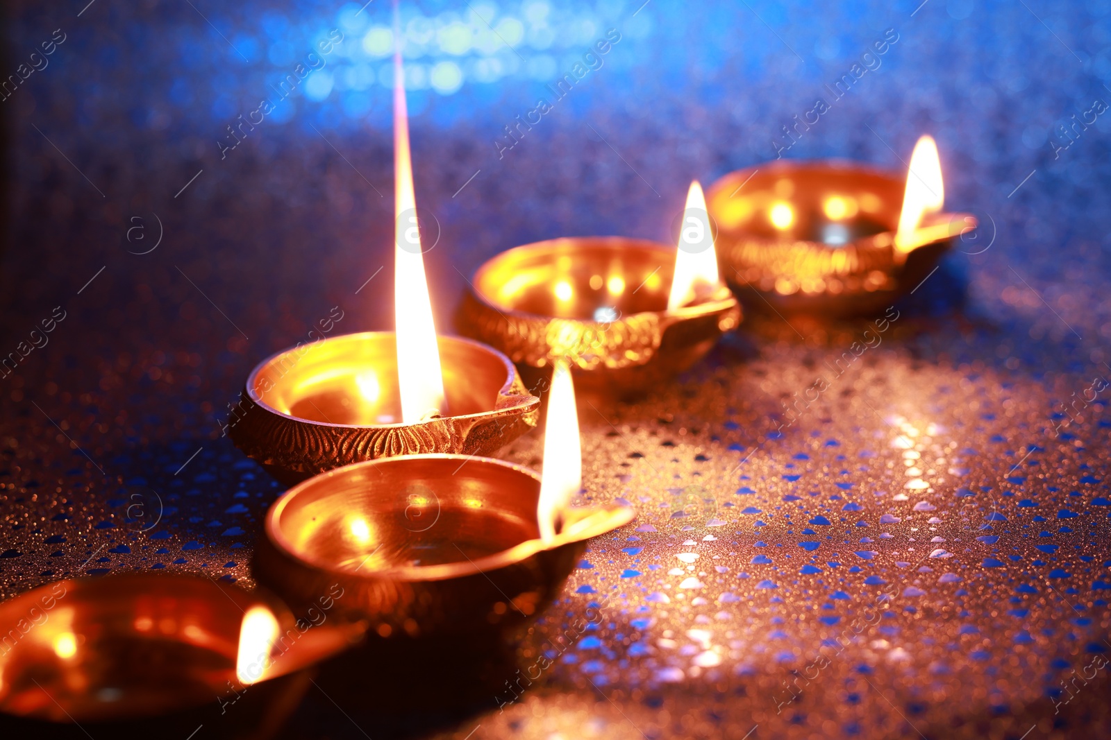 Photo of Diwali celebration. Diya lamps on color background, closeup