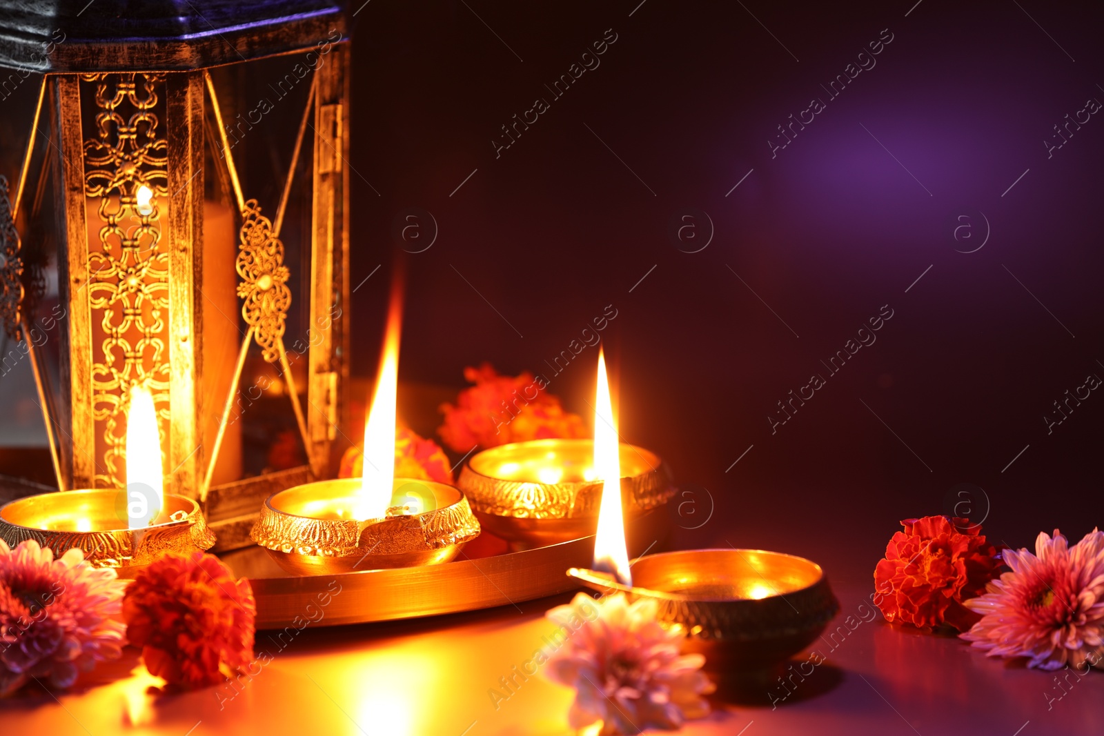 Photo of Diwali celebration. Diya lamps and beautiful flowers on color background, closeup