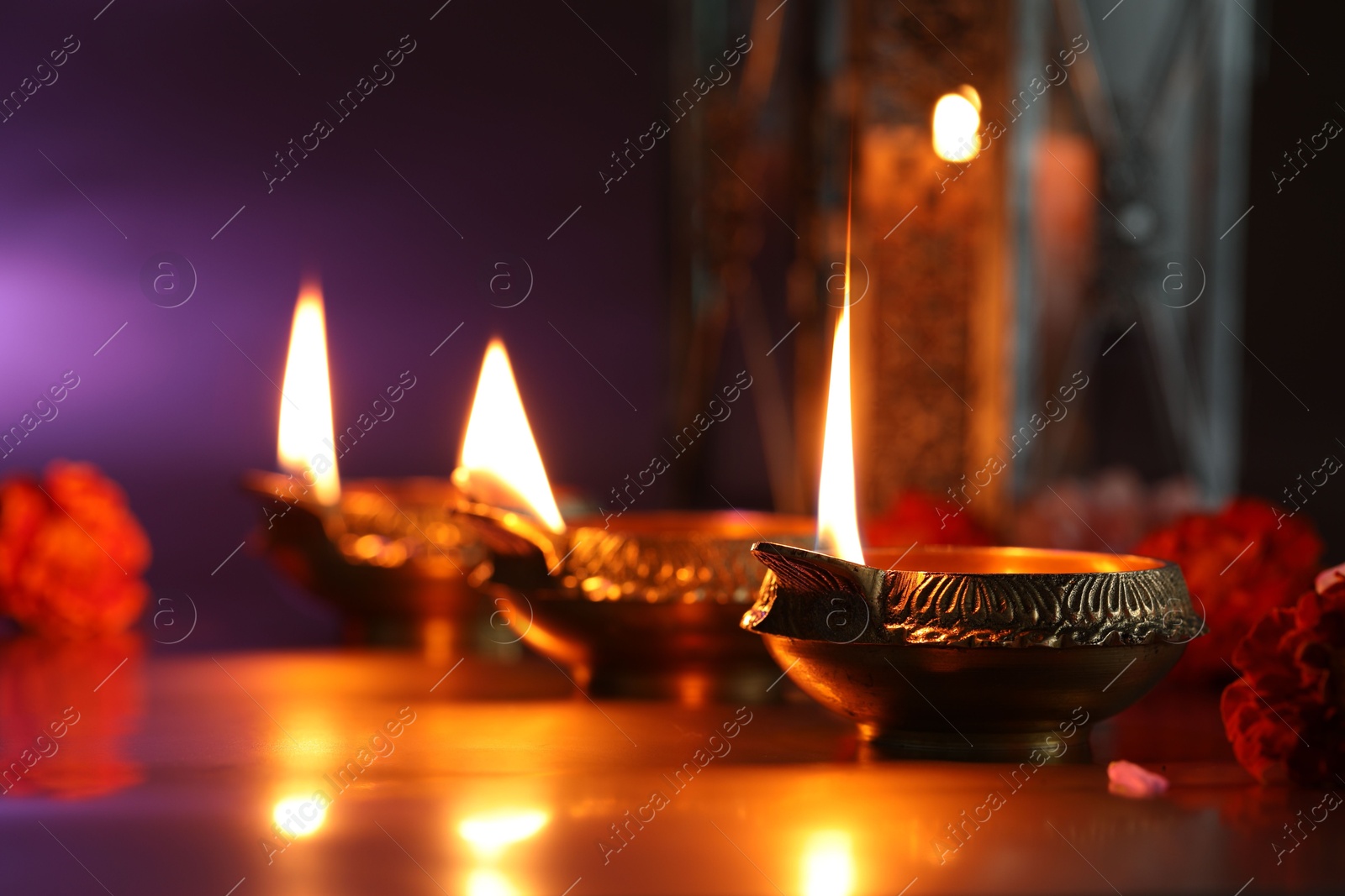 Photo of Diwali celebration. Diya lamps and beautiful flowers on color background, closeup