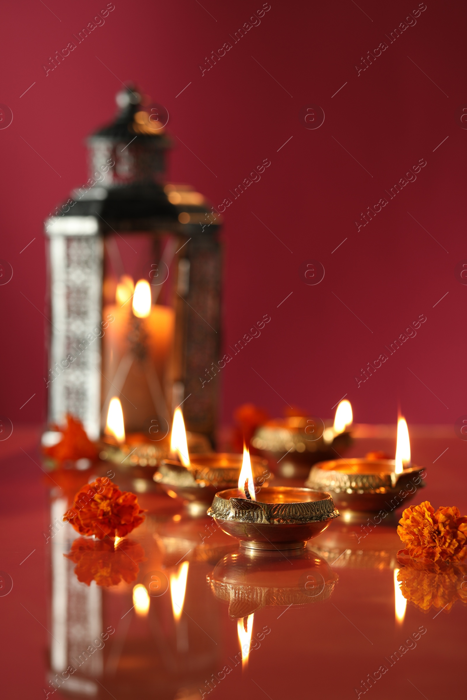 Photo of Diwali celebration. Diya lamps and beautiful flowers on color background