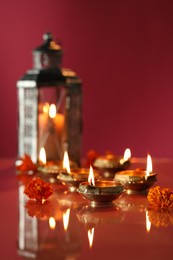 Photo of Diwali celebration. Diya lamps and beautiful flowers on color background