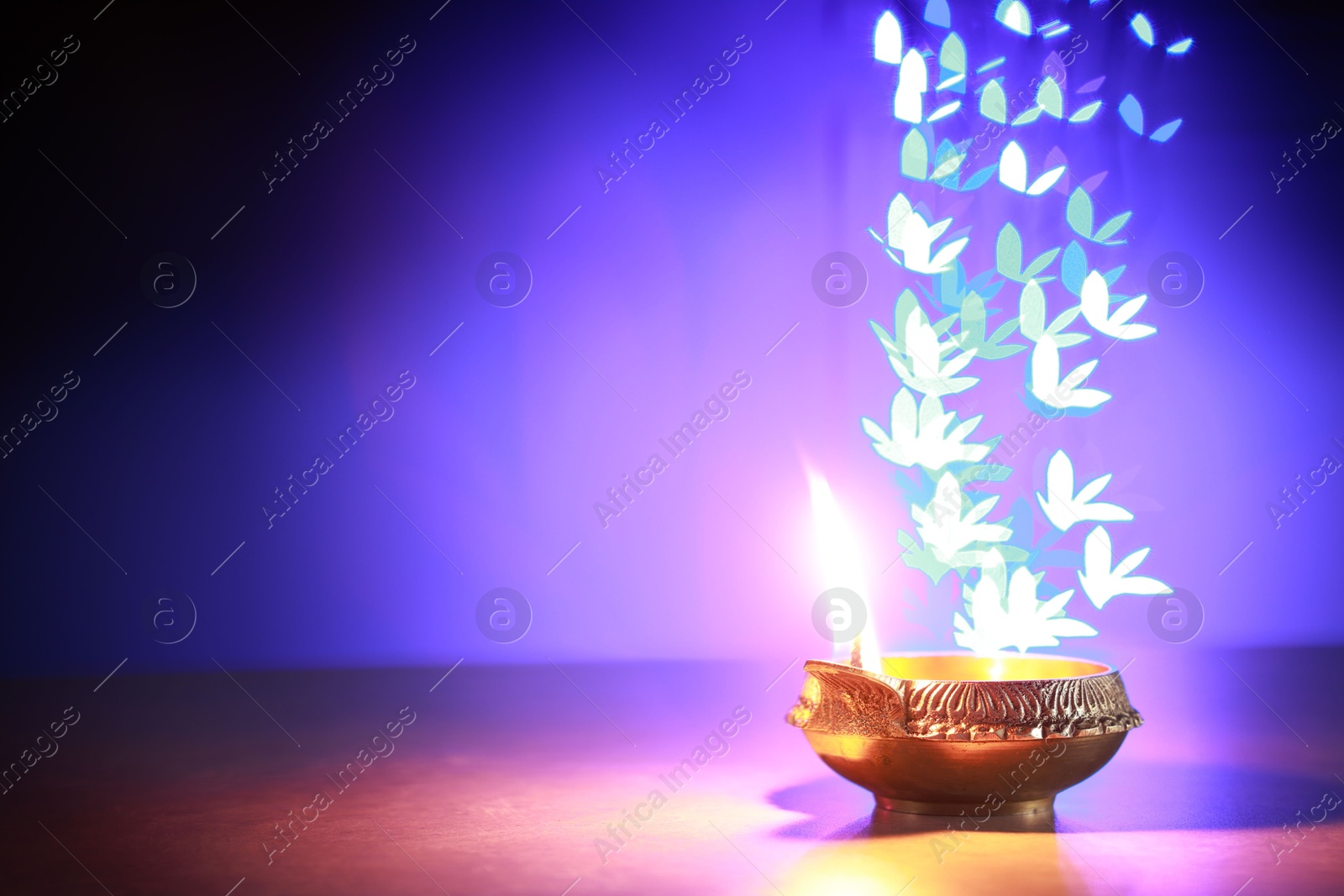 Photo of Diwali celebration. Diya lamp on color background, space for text