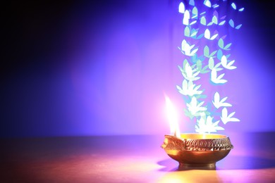 Photo of Diwali celebration. Diya lamp on color background, space for text