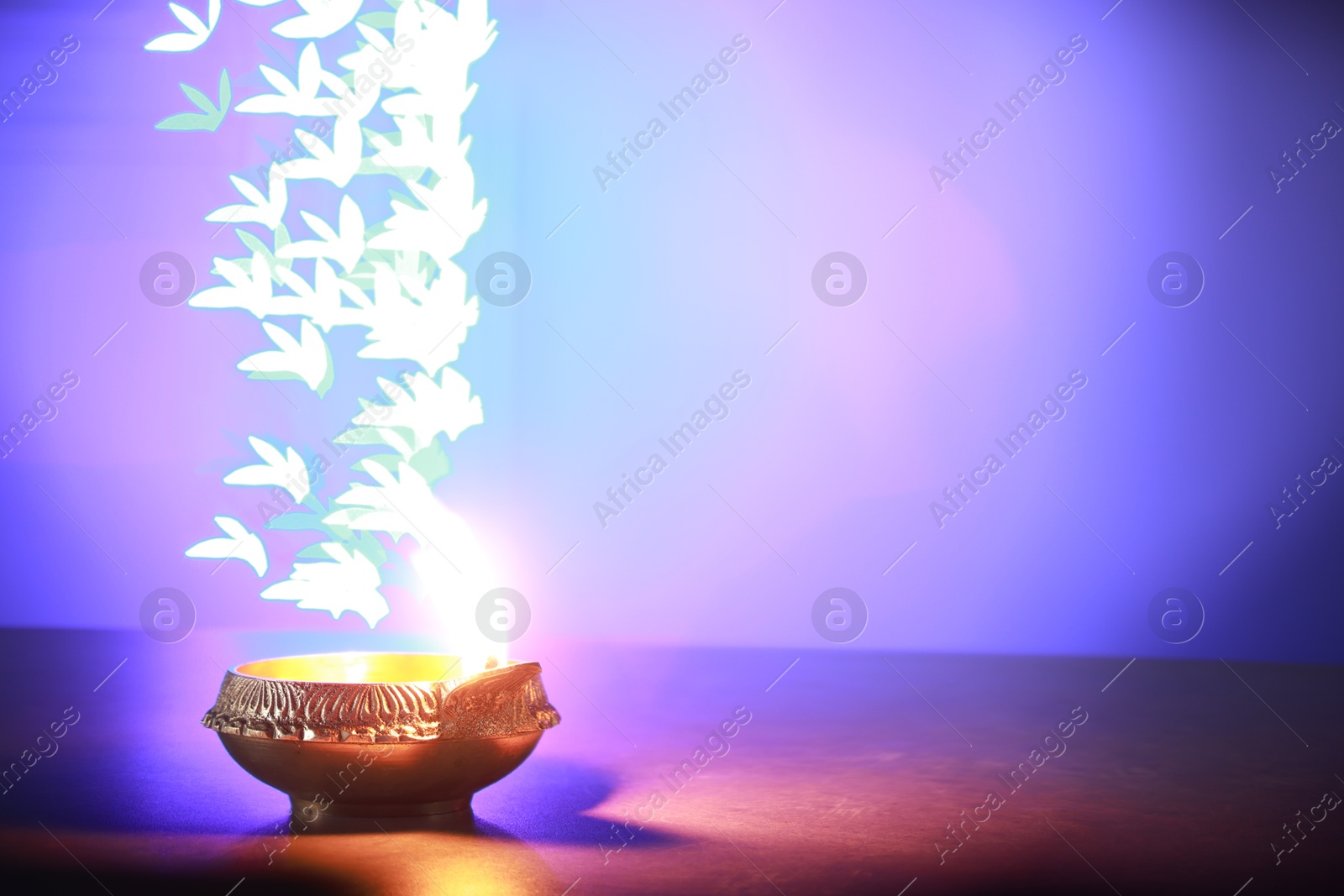 Photo of Diwali celebration. Diya lamp on color background, space for text