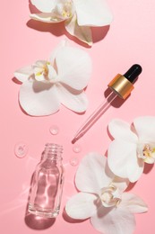 Photo of Beautiful orchid flowers and essential oil in water on pink background, flat lay