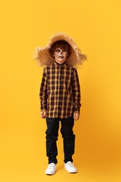 Funny boy dressed like scarecrow on yellow background. Halloween celebration