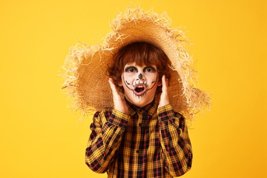 Funny boy dressed like scarecrow on yellow background. Halloween celebration