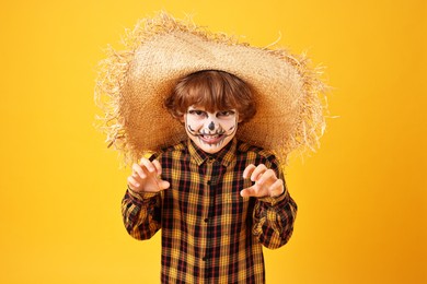 Photo of Funny boy dressed like scarecrow on yellow background. Halloween celebration