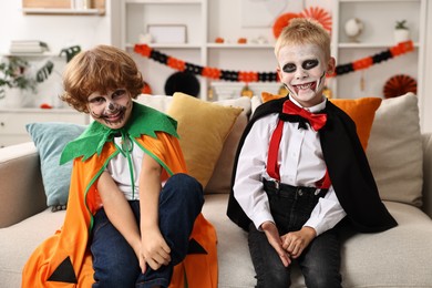 Funny children wearing costumes for Halloween celebration in room