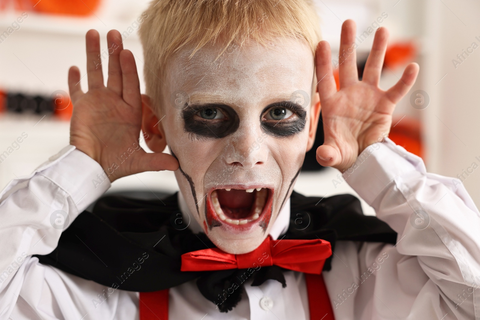 Photo of Funny boy dressed like vampire for Halloween celebration indoors