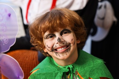 Photo of Funny children wearing costumes for Halloween celebration indoors, selective focus