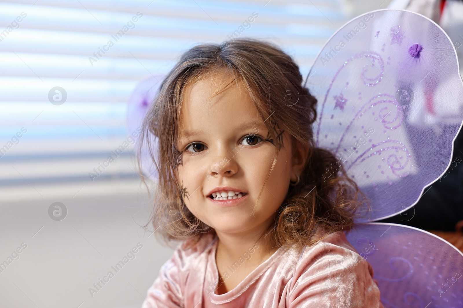 Photo of Cute girl dressed like fairy indoors. Halloween costume