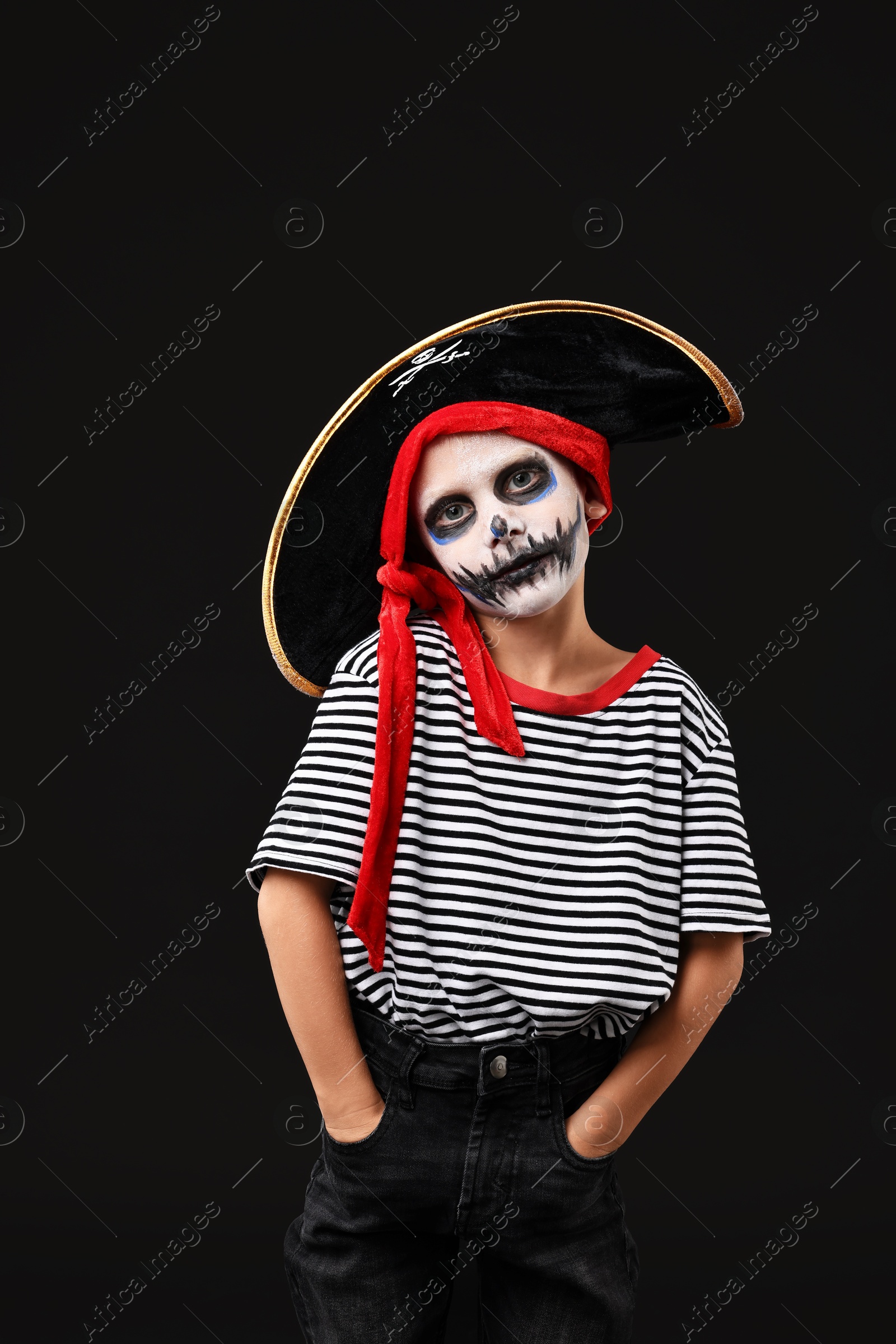 Photo of Funny boy dressed like pirate for Halloween celebration on black background