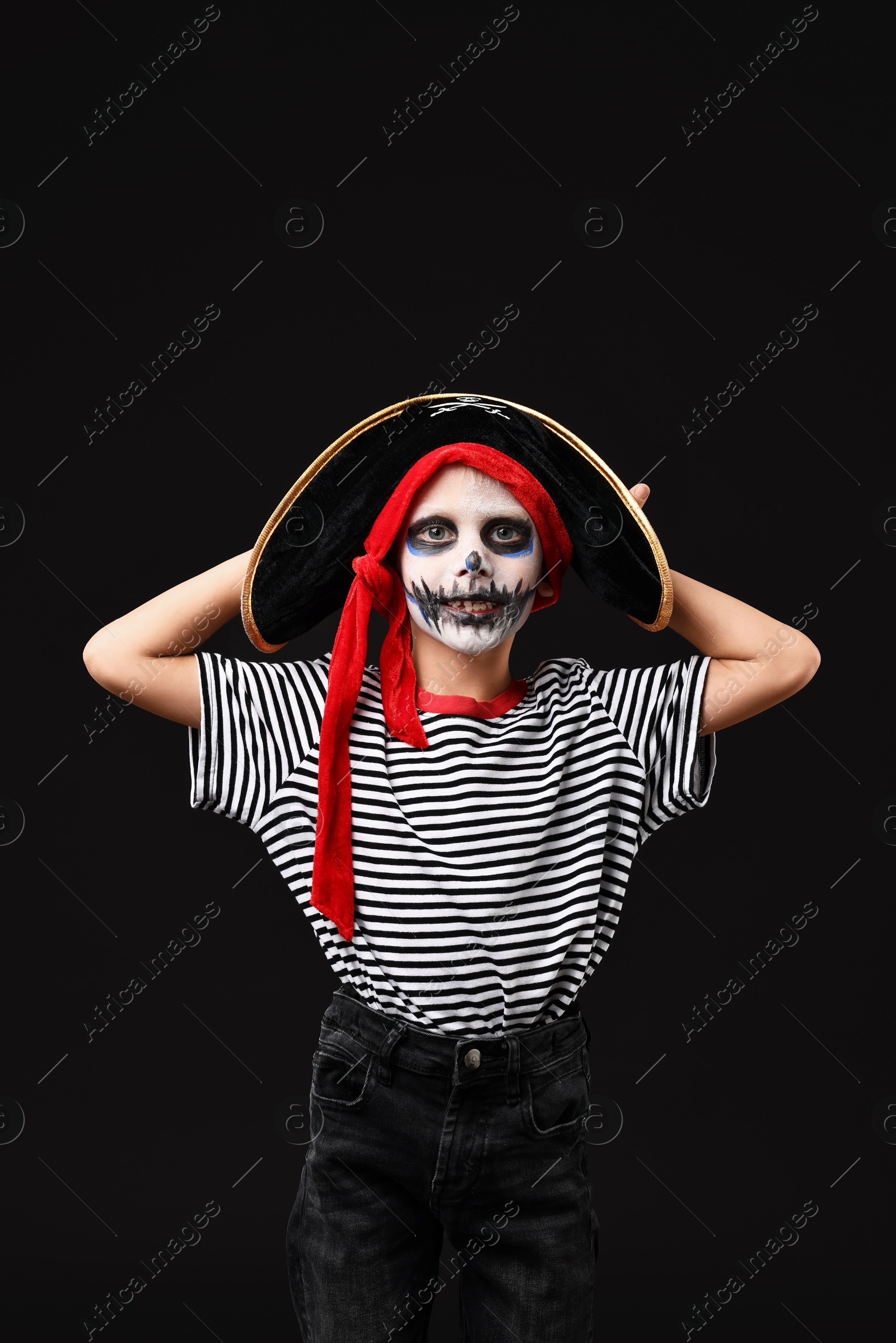 Photo of Funny boy dressed like pirate for Halloween celebration on black background