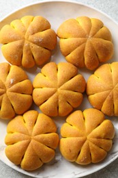 Photo of Tasty pumpkin shaped buns on grey table, top view