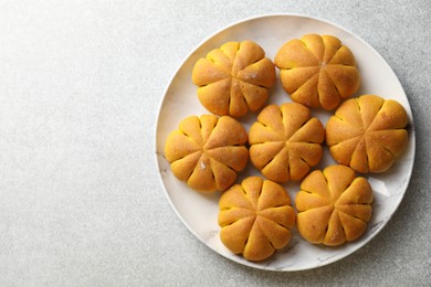 Photo of Tasty pumpkin shaped buns on grey table, top view. Space for text