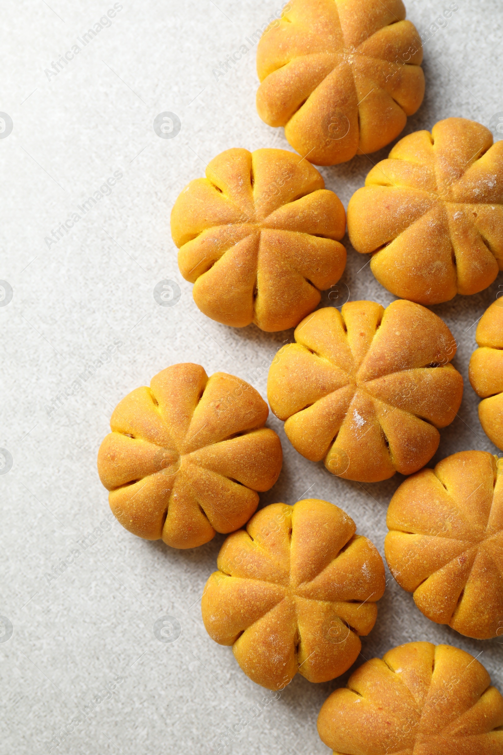 Photo of Tasty pumpkin shaped buns on grey table, flat lay