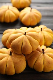 Photo of Pile of tasty pumpkin shaped buns on table, closeup