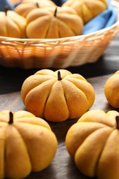 Photo of Tasty pumpkin shaped buns on table, closeup