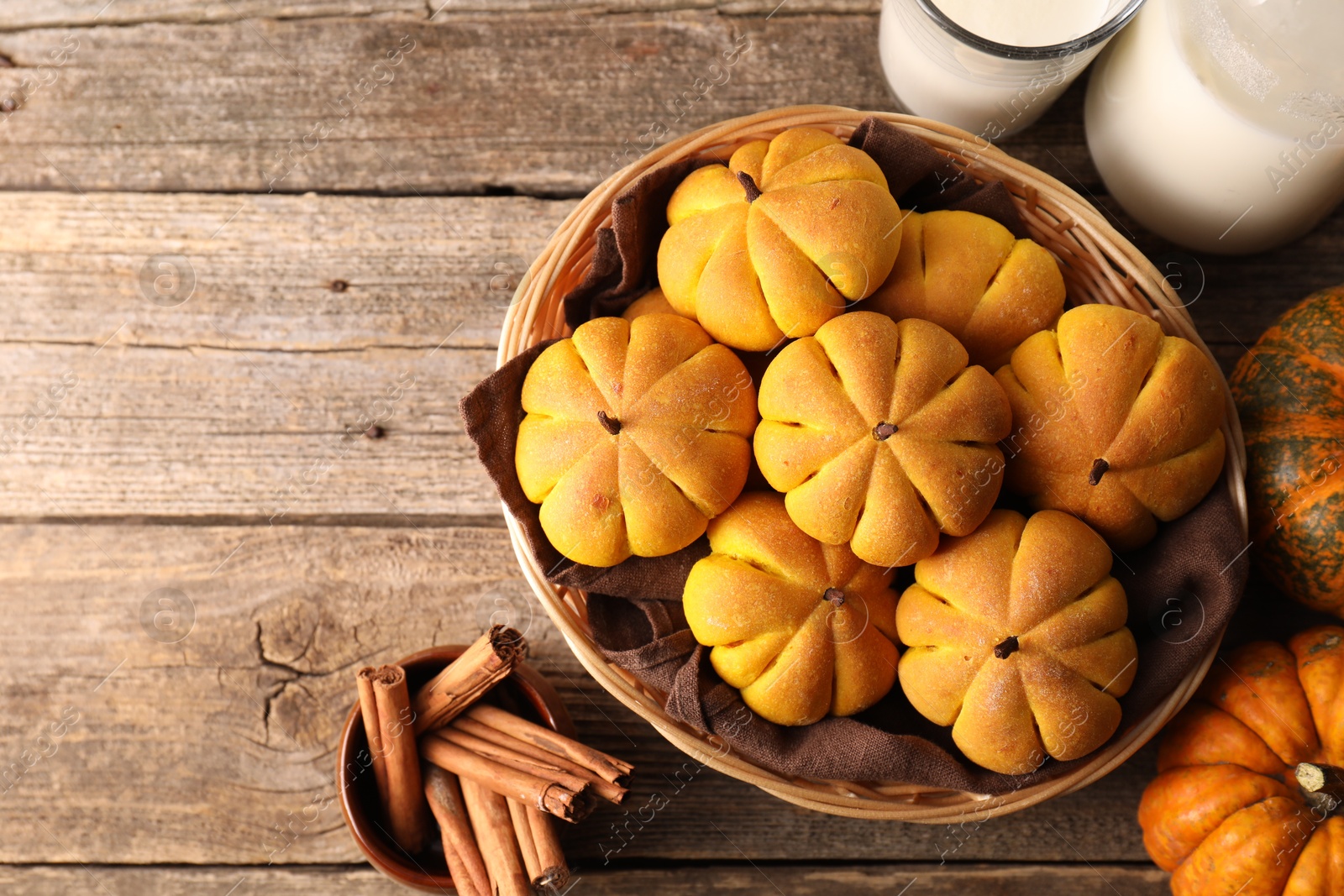 Photo of Flat lay composition with tasty pumpkin shaped buns on wooden table. Space for text