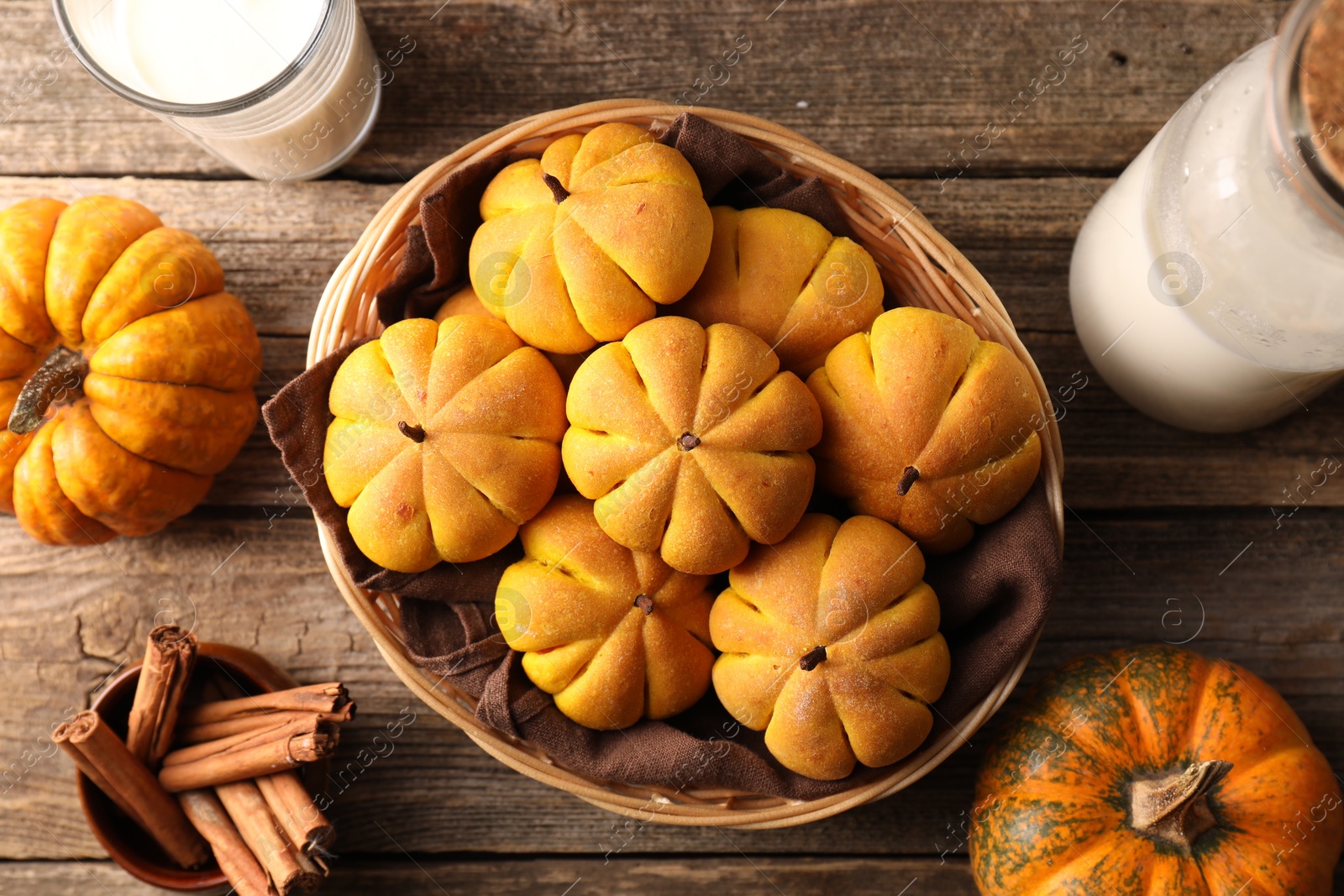 Photo of Flat lay composition with tasty pumpkin shaped buns on wooden table