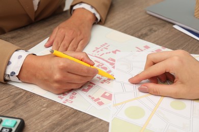 Real estate agent working with client at wooden table, closeup